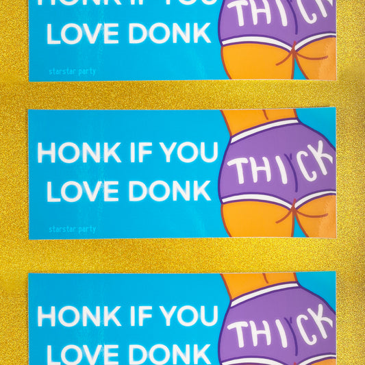 Three bumper stickers sit on a golden sparkly background. The sticker has a cartoon woman's backside, and she is wearing purple booty shorts that say "Thick" on the butt. The text on the bumper sticker reads, "Honk if you love donk".